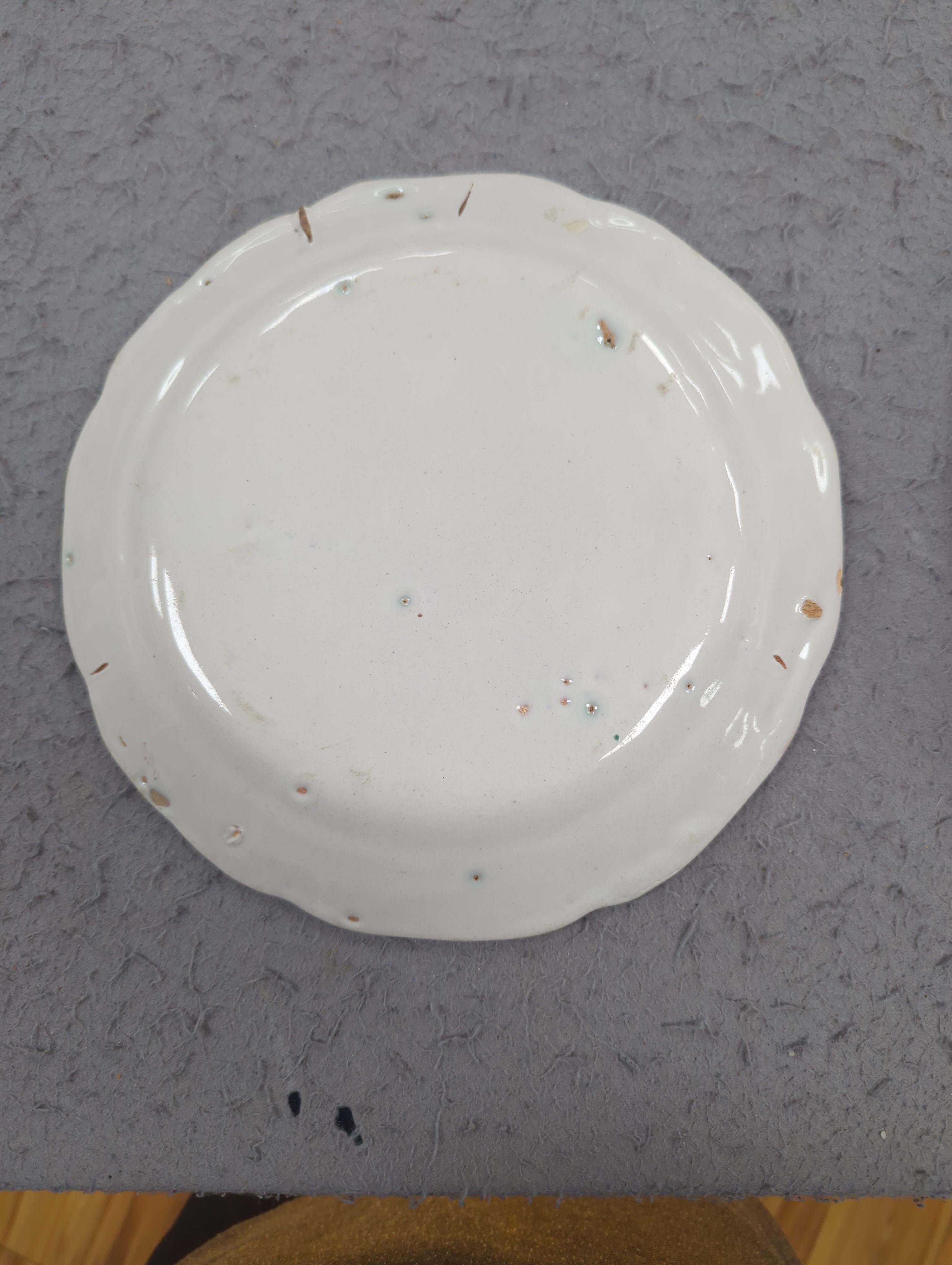 An 18th century Delft plate and three 19th century faience plates, largest 26cm diameter (4)